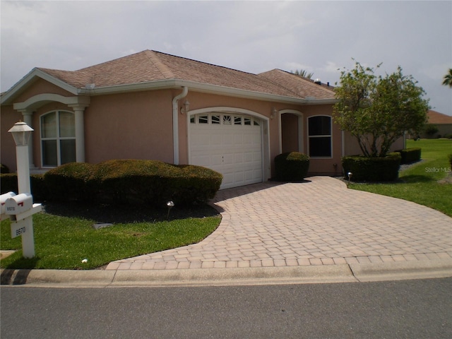 8670 SE 141st Pl, Summerfield, FL 34491 - ranch-style home featuring a garage, decorative driveway, and stucco siding