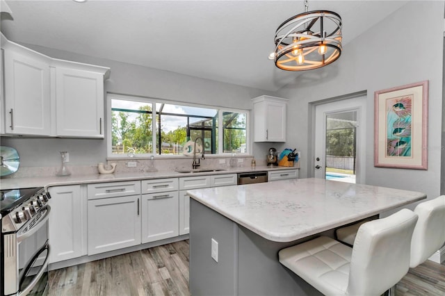 12392 SW 85th Pl, Dunnellon, FL 34432 - kitchen featuring appliances with stainless steel finishes, a chandelier, light wood finished floors, and healthy amount of natural light