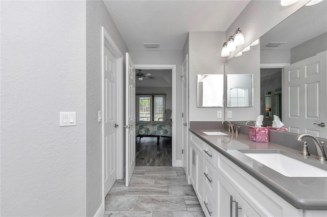12392 SW 85th Pl, Dunnellon, FL 34432 - ensuite bathroom featuring a textured wall, double vanity, marble finish flooring, and a ceiling fan