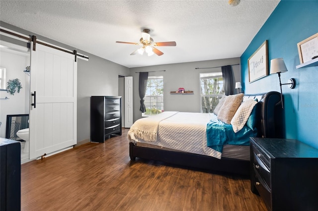 32 Dogwood Drive Loop, Ocala, FL 34472 - bedroom with a barn door, wood finished floors, a textured ceiling, and ceiling fan