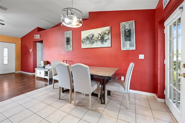 32 Dogwood Drive Loop, Ocala, FL 34472 - dining space with an accent wall, vaulted ceiling, plenty of natural light, a chandelier, and wood finished floors