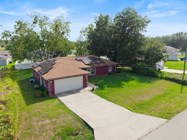 32 Dogwood Drive Loop, Ocala, FL 34472 - view of front of property with a front lawn, driveway, an attached garage, solar panels, and a shingled roof