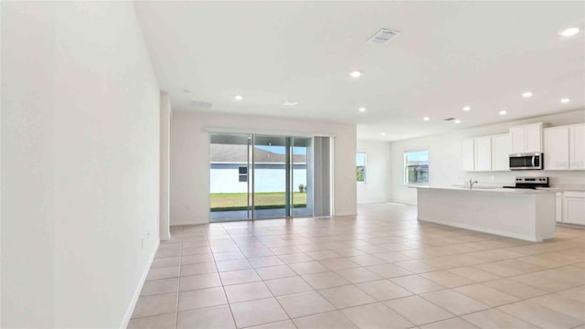 4508 SW 56th Pl, Gainesville, FL 32608 - unfurnished living room with light tile patterned floors, recessed lighting, a sink, and baseboards