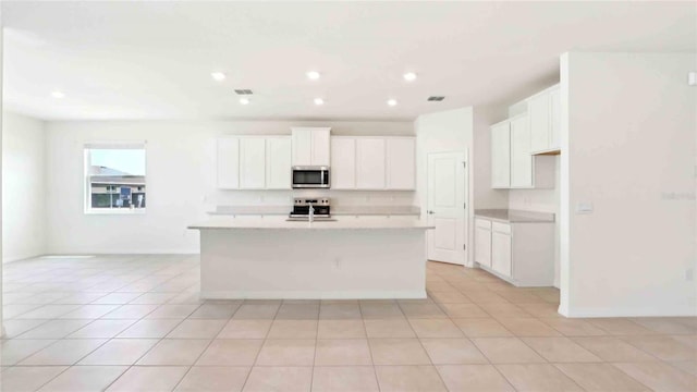 4508 SW 56th Pl, Gainesville, FL 32608 - kitchen with appliances with stainless steel finishes, an island with sink, white cabinetry, and recessed lighting
