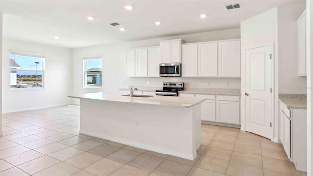 4508 SW 56th Pl, Gainesville, FL 32608 - kitchen featuring appliances with stainless steel finishes, a sink, white cabinetry, a kitchen island with sink, and recessed lighting