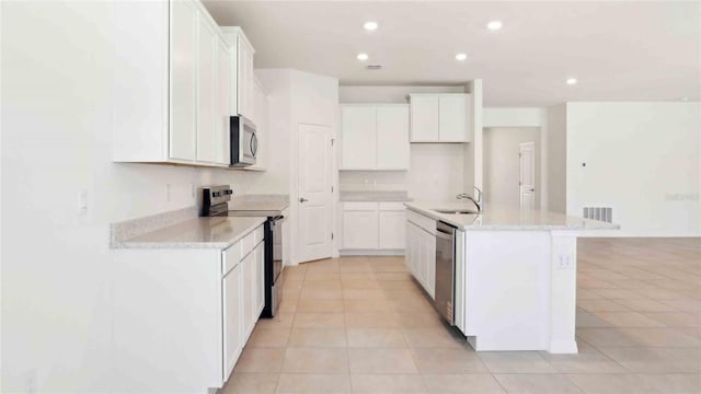 4508 SW 56th Pl, Gainesville, FL 32608 - kitchen featuring stainless steel appliances, a sink, light tile patterned floors, recessed lighting, and white cabinetry