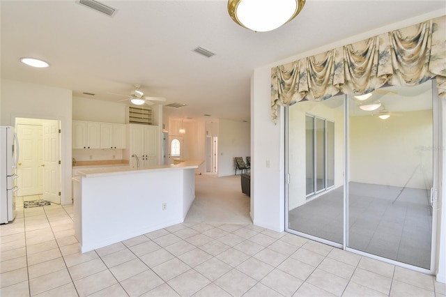 5551 NW 25th Loop, Ocala, FL 34482 - kitchen featuring ceiling fan, freestanding refrigerator, light countertops, white cabinets, and light tile patterned floors