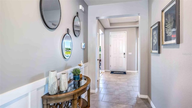 4484 SW 56th Pl, Gainesville, FL 32608 - hallway featuring tile patterned flooring, a tray ceiling, and baseboards