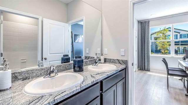 4484 SW 56th Pl, Gainesville, FL 32608 - bathroom featuring double vanity, wood finished floors, and baseboards