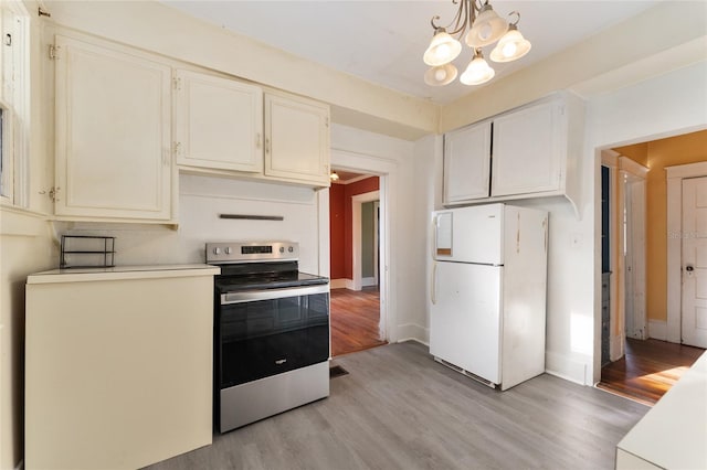 1434 SE Silver Springs Pl, Ocala, FL 34471 - kitchen featuring stainless steel electric range, freestanding refrigerator, light wood-style floors, a chandelier, and baseboards