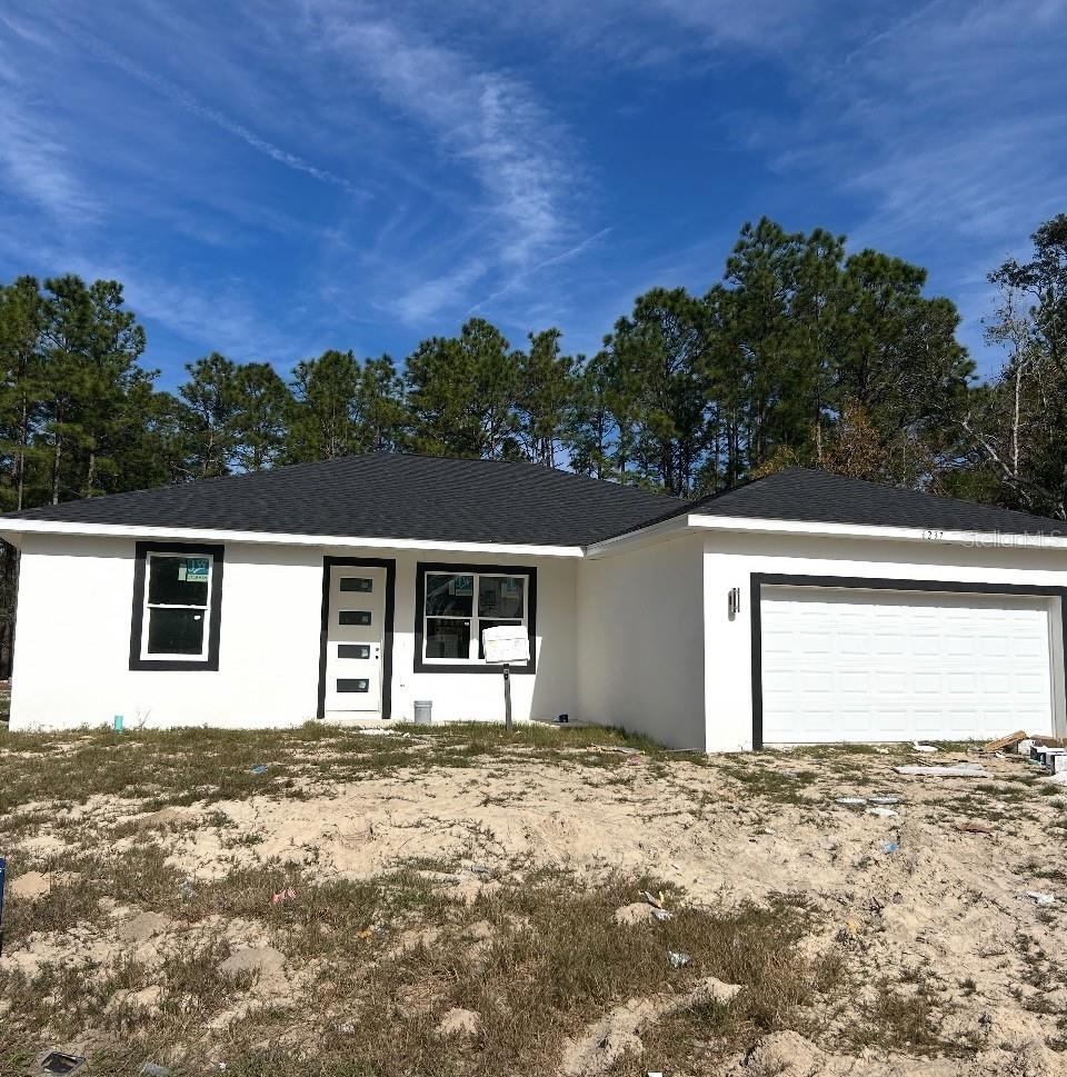 7604 SW 103rd Loop, Ocala, FL 34476 - ranch-style home with stucco siding and an attached garage