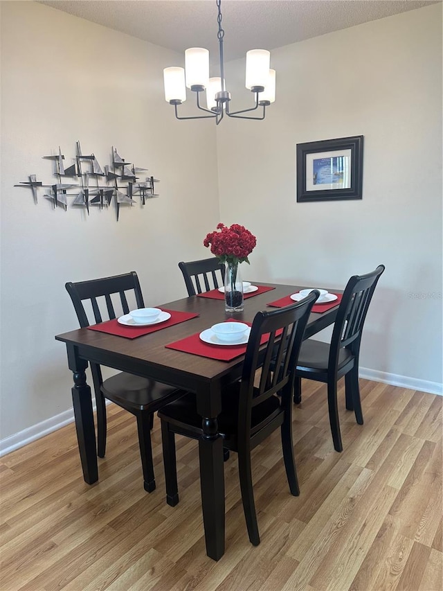 9255 SW 90th Ct Unit B, Ocala, FL 34481 - dining area featuring a chandelier, light wood-style floors, and baseboards