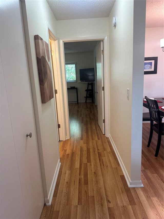 9255 SW 90th Ct Unit B, Ocala, FL 34481 - hall featuring light wood-type flooring, a textured ceiling, and baseboards