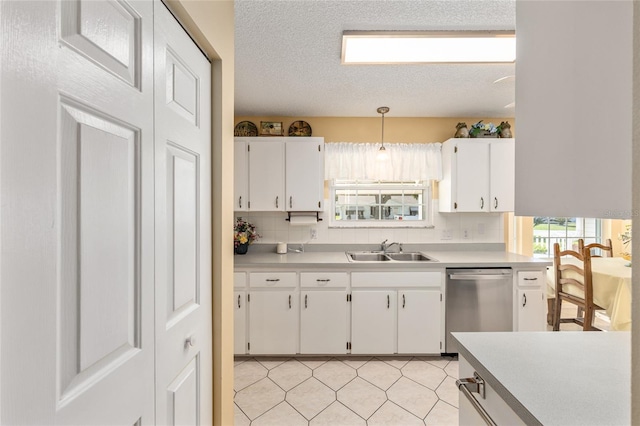 8554 SW 63rd Ct, Ocala, FL 34476 - kitchen featuring dishwasher, light countertops, white cabinets, a textured ceiling, and tasteful backsplash