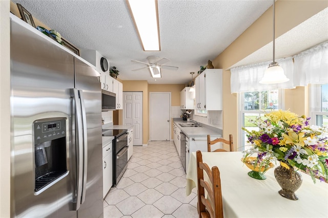 8554 SW 63rd Ct, Ocala, FL 34476 - kitchen with appliances with stainless steel finishes, white cabinetry, a ceiling fan, decorative backsplash, and light countertops