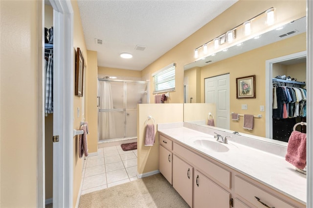 8554 SW 63rd Ct, Ocala, FL 34476 - bathroom featuring a walk in closet, vanity, a shower stall, tile patterned floors, and a textured ceiling