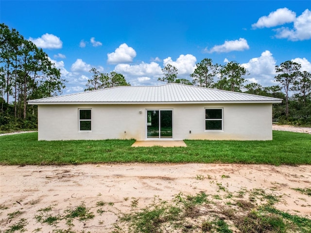 9131 Canter Path, Sebring, FL 33870 - rear view of property with stucco siding, a metal roof, and a yard