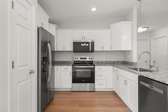 9131 Canter Path, Sebring, FL 33870 - kitchen featuring appliances with stainless steel finishes, white cabinets, light stone counters, decorative light fixtures, and recessed lighting
