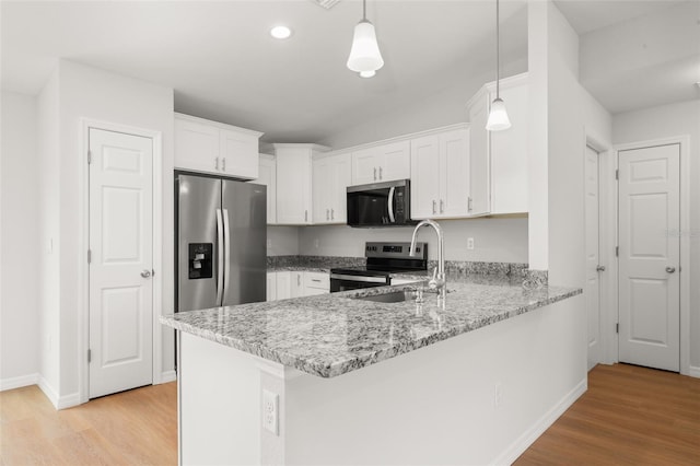 9131 Canter Path, Sebring, FL 33870 - kitchen featuring stainless steel appliances, white cabinetry, a peninsula, light wood finished floors, and light stone counters