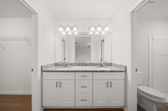 9131 Canter Path, Sebring, FL 33870 - full bathroom featuring double vanity, a walk in closet, and wood finished floors