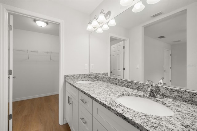 9131 Canter Path, Sebring, FL 33870 - full bathroom featuring double vanity, wood finished floors, and a walk in closet