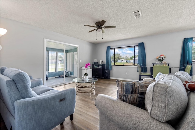 10210 SW 93rd Ave, Ocala, FL 34481 - living area with healthy amount of natural light, a ceiling fan, wood finished floors, and a textured ceiling