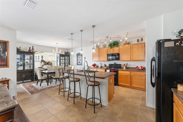 6646 SW 64th Ave, Ocala, FL 34476 - kitchen featuring black appliances, a kitchen bar, dark countertops, and a chandelier