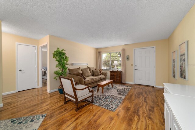 8431 SW 93rd Pl Unit F, Ocala, FL 34481 - living area with wood finished floors, a textured ceiling, and baseboards