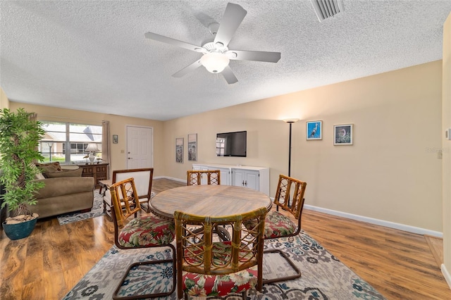 8431 SW 93rd Pl Unit F, Ocala, FL 34481 - dining room with a textured ceiling, baseboards, wood finished floors, and a ceiling fan
