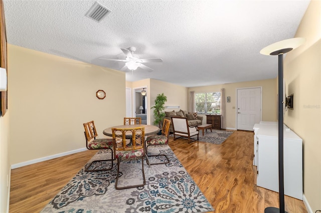 8431 SW 93rd Pl Unit F, Ocala, FL 34481 - dining space featuring light wood finished floors, a textured ceiling, a ceiling fan, and baseboards