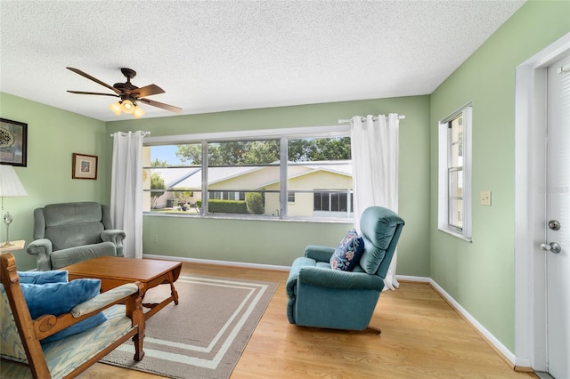 8431 SW 93rd Pl Unit F, Ocala, FL 34481 - living room with wood finished floors, a textured ceiling, a ceiling fan, and baseboards