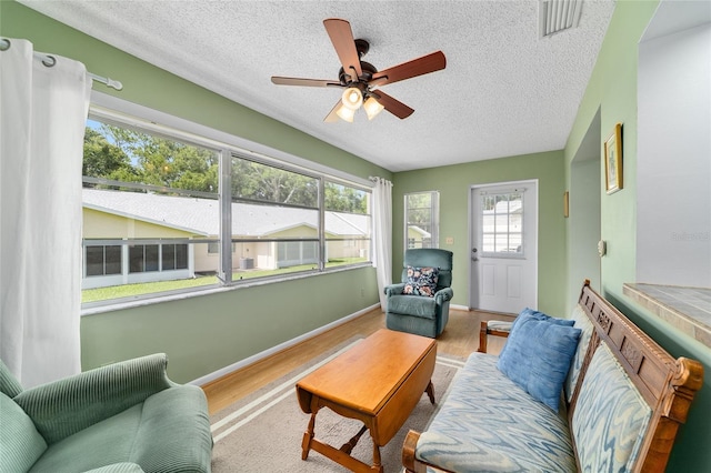 8431 SW 93rd Pl Unit F, Ocala, FL 34481 - living room featuring wood finished floors, a textured ceiling, ceiling fan, and baseboards
