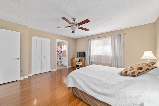 8431 SW 93rd Pl Unit F, Ocala, FL 34481 - bedroom featuring wood finished floors, baseboards, a textured ceiling, a ceiling fan, and ensuite bathroom