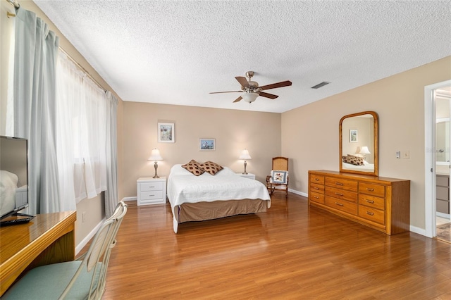 8431 SW 93rd Pl Unit F, Ocala, FL 34481 - bedroom featuring wood finished floors, a textured ceiling, baseboards, and ceiling fan