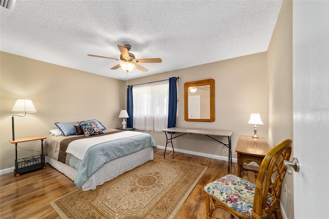 8431 SW 93rd Pl Unit F, Ocala, FL 34481 - bedroom with wood finished floors, baseboards, a textured ceiling, and a ceiling fan