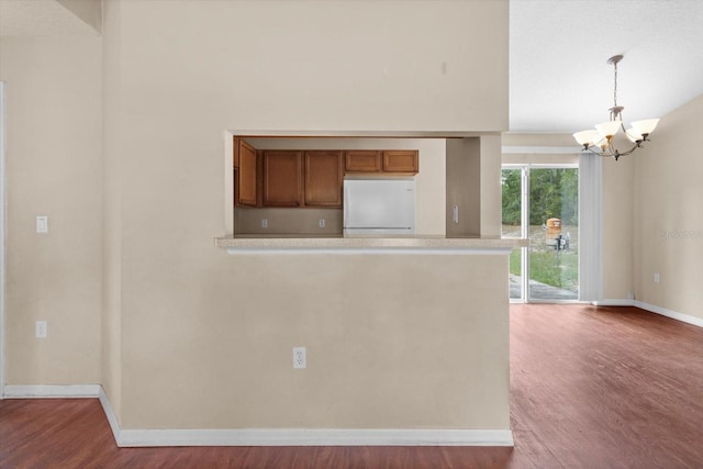 23340 NW Columbine Ave, Dunnellon, FL 34431 - kitchen featuring freestanding refrigerator, a chandelier, baseboards, wood finished floors, and brown cabinetry