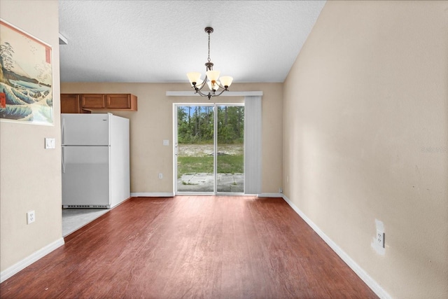 23340 NW Columbine Ave, Dunnellon, FL 34431 - unfurnished dining area with wood finished floors, a chandelier, and baseboards
