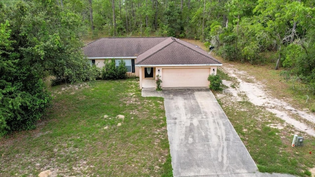 23340 NW Columbine Ave, Dunnellon, FL 34431 - ranch-style house featuring driveway, an attached garage, a front yard, and a wooded view