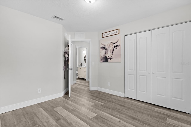 18 Banyan Pass, Ocala, FL 34472 - unfurnished bedroom featuring wood finished floors, a closet, baseboards, and a textured ceiling