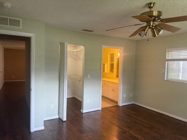 9722 SW 95th Ct Unit C, Ocala, FL 34481 - unfurnished bedroom with wood finished floors, a textured ceiling, a spacious closet, a closet, and ensuite bathroom