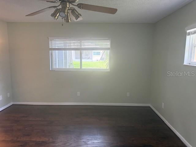 9722 SW 95th Ct Unit C, Ocala, FL 34481 - unfurnished room with a ceiling fan, dark wood-style floors, and a textured ceiling