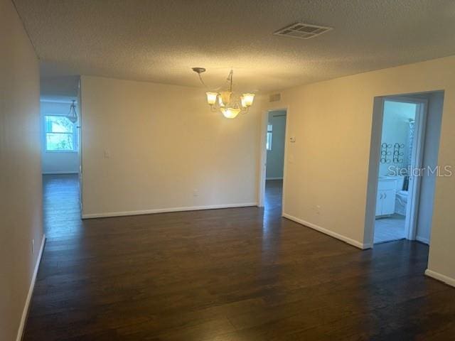 9722 SW 95th Ct Unit C, Ocala, FL 34481 - unfurnished room featuring a chandelier, dark wood finished floors, and a textured ceiling