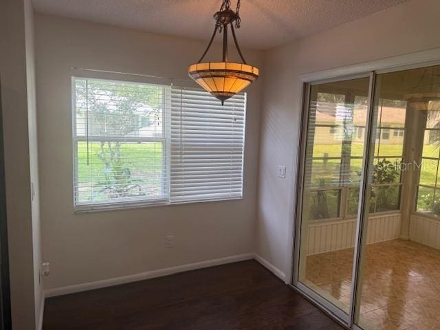 9722 SW 95th Ct Unit C, Ocala, FL 34481 - unfurnished dining area featuring dark wood-type flooring and a textured ceiling