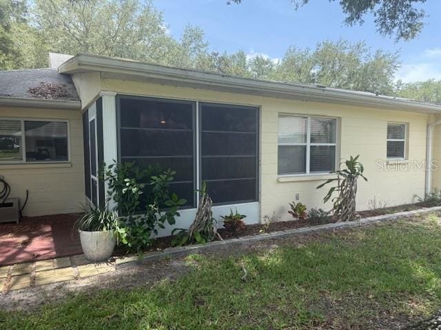 9722 SW 95th Ct Unit C, Ocala, FL 34481 - view of home's exterior featuring a sunroom and concrete block siding