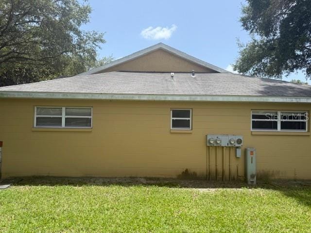9722 SW 95th Ct Unit C, Ocala, FL 34481 - view of home's exterior featuring concrete block siding, a lawn, and roof with shingles