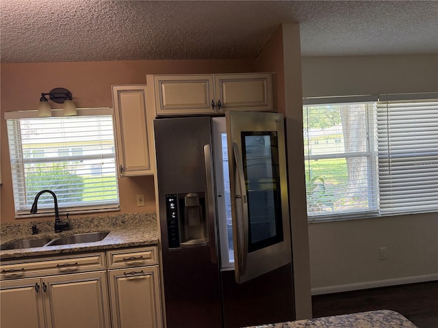 9722 SW 95th Ct Unit C, Ocala, FL 34481 - kitchen featuring stainless steel refrigerator with ice dispenser, a textured ceiling, and light stone counters