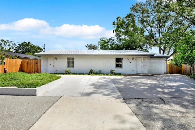 6816 Thomas Cir, Tampa, FL 33619 - single story home with stucco siding, a garage, a metal roof, and driveway