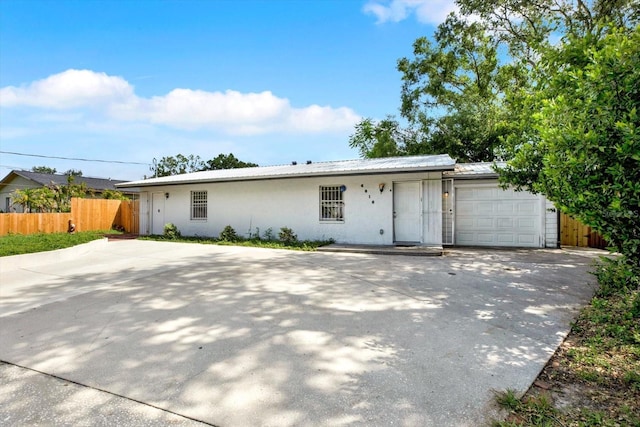 6816 Thomas Cir, Tampa, FL 33619 - ranch-style home featuring a garage, stucco siding, driveway, and a metal roof