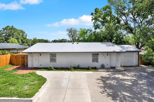 6816 Thomas Cir, Tampa, FL 33619 - single story home with a metal roof, stucco siding, and an attached garage