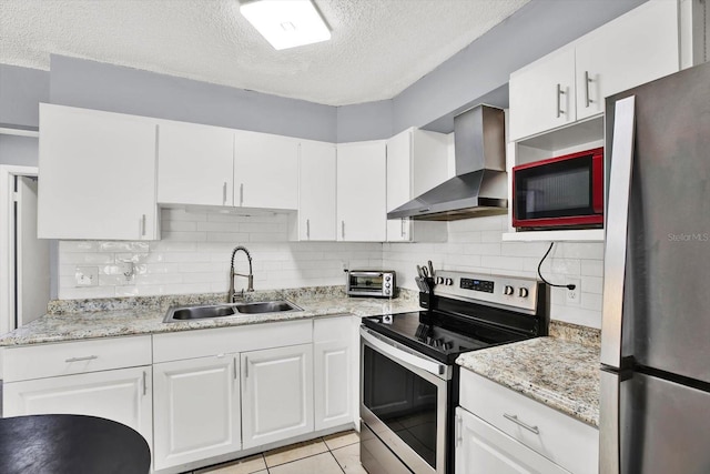 6816 Thomas Cir, Tampa, FL 33619 - kitchen with appliances with stainless steel finishes, wall chimney range hood, a textured ceiling, tasteful backsplash, and white cabinetry